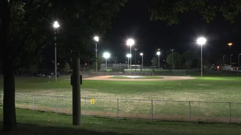 Empty baseball diamond lights on at night during COVID 19 pandemic lockdown Stock Footage 139559952