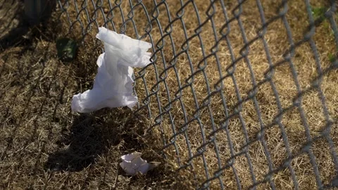 Empty baseball diamond with trash stuck to a fence on a hot summer day Vídeos de archivo 277404939