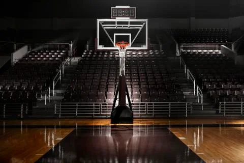 Empty basketball arena with dramatic lighting, view from free throw line in Stock Photos
