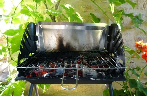 An empty BBQ showing the red hot coals heating up ready to start cooking Stock Photos