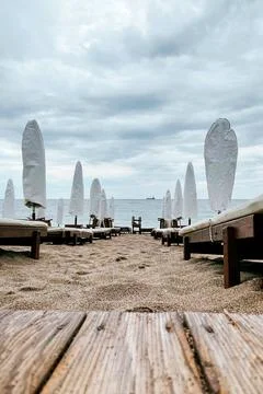 Empty beach Adriatic Sea cloudy day, sun umbrellas rolled up loungers removed Stock Photos