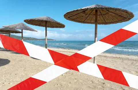 Empty beach with barrier tape, closed summer beach Stock Photos
