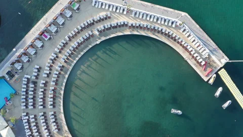 Empty beach beds on the concrete beach - pier or dock lining a small marina Stock Footage 213631895