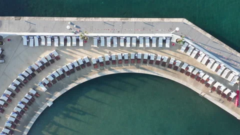 Empty beach beds on the concrete beach - pier or dock lining a small marina Stock Footage 213644137