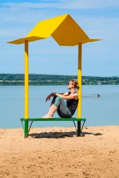 Empty beach with a bench with a canopy on the coast Stock Photos