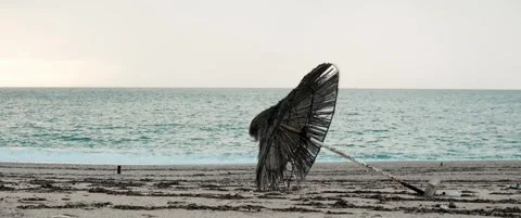 Empty beach with broken umbrella and calm sea Stock Footage 328936394