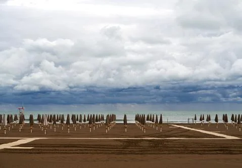 Empty beach in Caorle at the end of September under a heavy cloudy sky. Stock Photos
