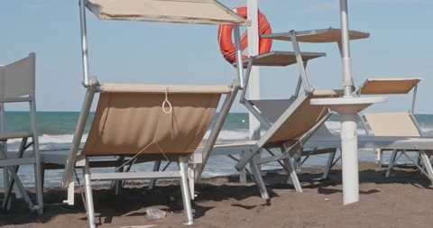 Empty beach chairs and sunbeds in front of the beach with rough seas 動画素材 172446901