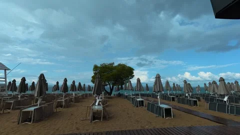 Empty beach with closed umbrellas and chairs. Lagomandra, Greece Stock Footage 340637820
