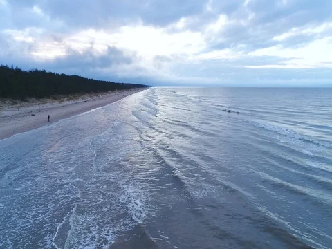 Empty beach Coastline with breaking waves on cloudy day Stock Footage 84296399