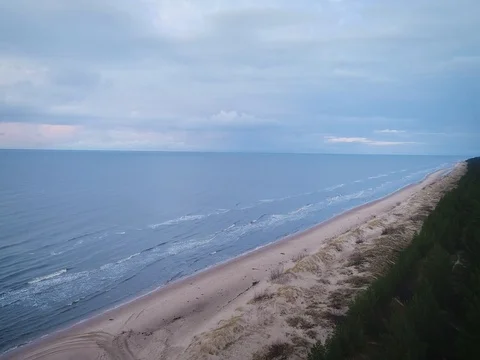Empty beach Coastline with breaking waves on cloudy day Stock Footage 84296474