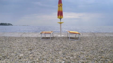 Empty beach deck chair, sea ​​lounger, wind and rough sea. Stock Footage 161134293