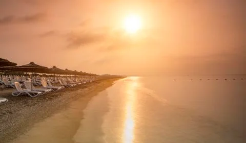 Empty beach during sunrise Stock Photos