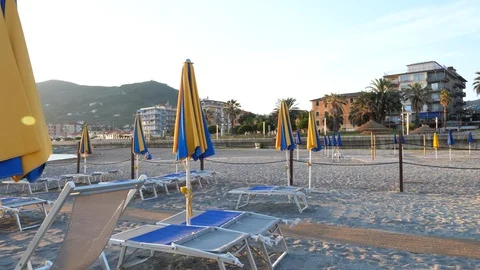 Empty beach filled with umbrellas at sunset  Stock Footage 93440840