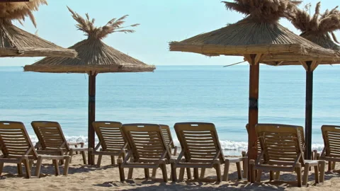 Empty Beach Lounge Chairs on the Ocean During Tourist Season Stock Footage 308496890