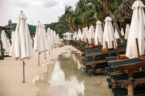 Empty beach lounge chairs under white umbrellas at a tropical resort Foto stock
