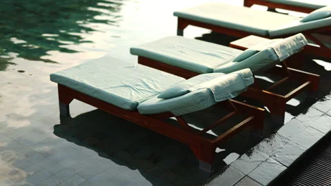 Empty beach lounger by the water at sunset Stock Footage 242748574