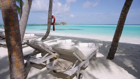 Empty Beach Loungers and Turquoise Lagoon at Gili Lankanfushi Stock Footage 340773229