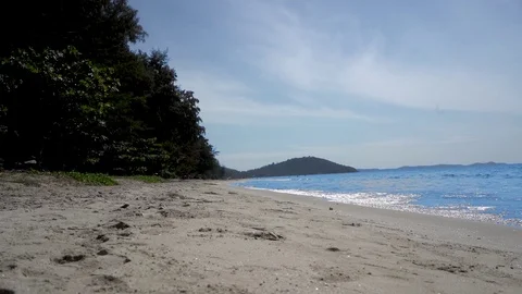 Empty beach, near the visible island. In the sand shells. Stock Footage 101466077