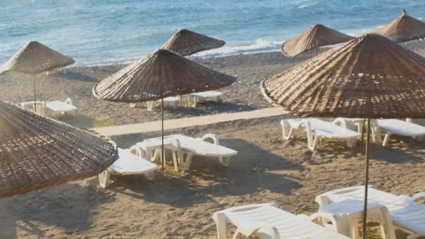 Empty beach resort with traditional wicker parasols and sunbeds overlooking 動画素材 333663212