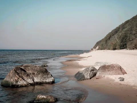 Empty beach with rocks in foreground. Stock Photos