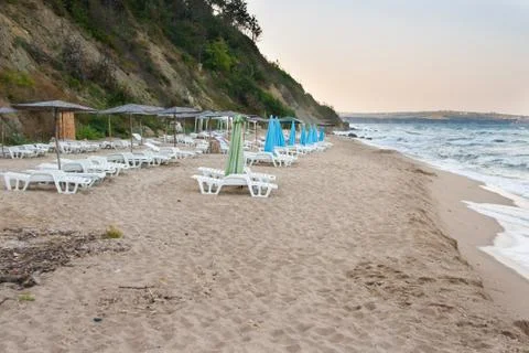 Empty beach on the seaside at the end of day with empty sun loungers and Stock Photos