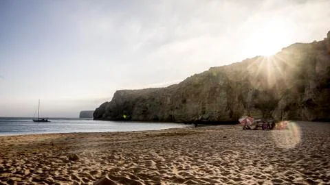 Empty beach with sun and distant cliffs panoramic Stock Photos