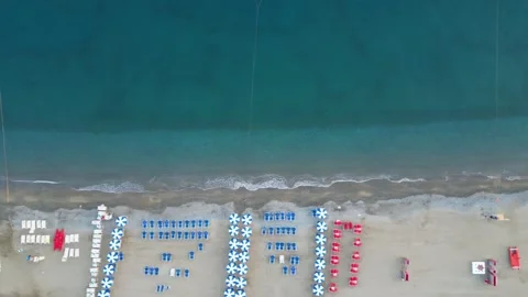 Empty beach with sun loungers and parasols on the sea coast, view from a drone. Stock Footage 255850355