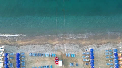 Empty beach with sun loungers and parasols on the sea coast, view from a drone. Stock Footage 255859088