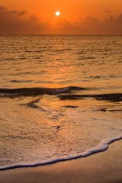 Empty beach at sunset Stock Photos