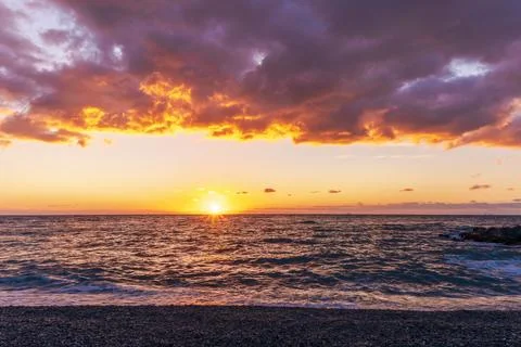 Empty beach with surf during beautiful sunrise or sunset with surf, clouds .. Stock Photos