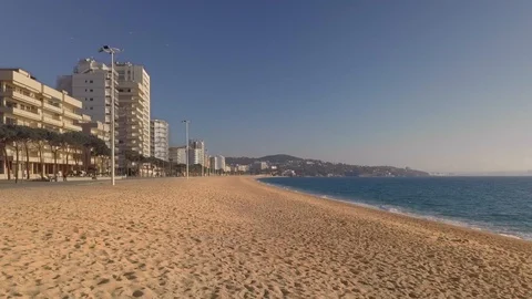 Empty beach in a tourist area on a sunny day, drone slow flight Stock Footage