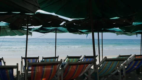 Empty beach umbrellas and chairs by the sea Video stock 332846802