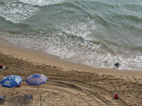 Empty beach with umbrellas placed in the sand Stock Photos