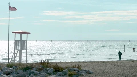 Empty Beach with white Lifeguard cabin and red flag Stock Footage 117409529