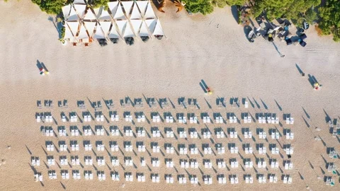 Empty beach with white sand and sun loungers, by the sea with turquoise water Stock Footage 213646394