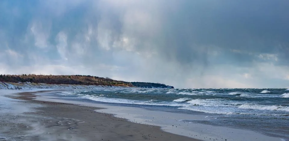 Empty beach wind with tree line against the cloudy sky in Palanga city Stock Photos