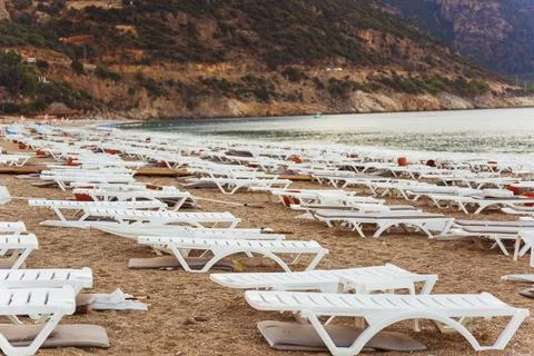 Empty beautiful beach with white sun loungers Stock Photos