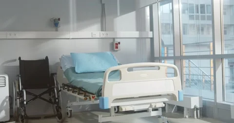 Empty bed and wheelchair n modern hospital room Stock Footage 154149345