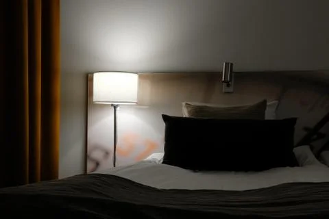 Empty bed in a hotel room Stock Photos