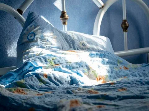 Empty bed lit by the sun Stock Photos