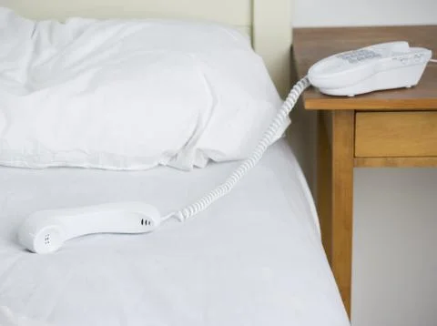 Empty bed with telephone Stock Photos