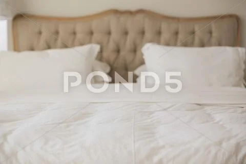 Empty bed with white duvet cover Stock Photos