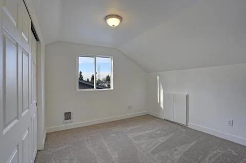 Empty bedroom interior with vaulted ceiling on the upper floor. The room has  Stock Photos