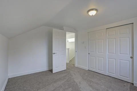 Empty bedroom interior with vaulted ceiling on the upper floor. The room has  Stock Photos