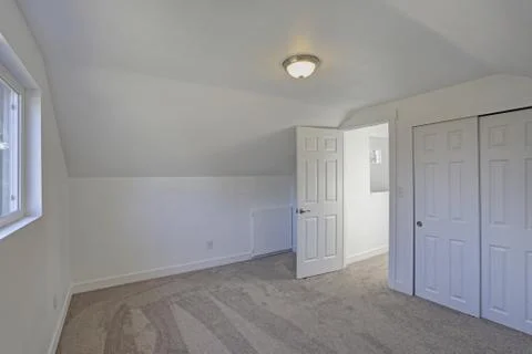 Empty bedroom interior with vaulted ceiling on the upper floor. The room has  Stock Photos
