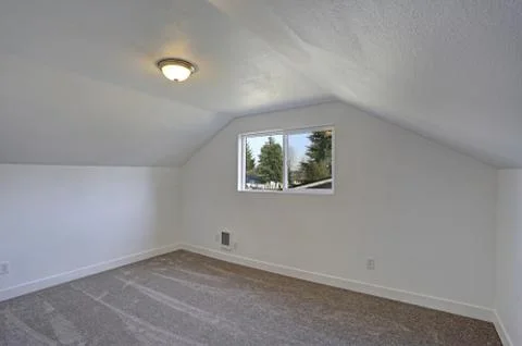 Empty bedroom interior with vaulted ceiling on the upper floor. The room has  Stock Photos