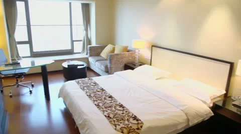 Empty bedroom with tv set on table and sofa near window Stock Footage 12657805