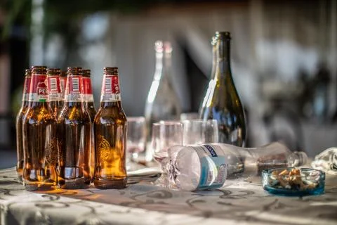 Empty Beer bottles and full ashtray Stock Photos