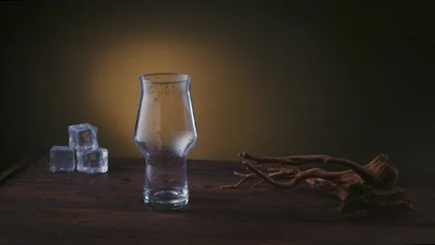 Empty beer pint on a wooden table with ice, smoke rises against the background Stock-Footage 131064943